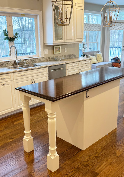 A beautiful kitchen island had a fresh coat of dark stain on the counter, with a country cream base paint.  Walls were painted silver.